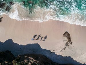 a-group-of-people-standing-on-top-of-a-sandy-beach